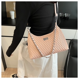 Close-up of pleated leather shoulder bag with silver chain and vertical texture