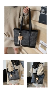 Detail of grey marble pattern tote bag with leather straps and bear charm accessory