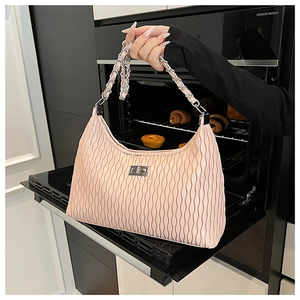 Detail of pink pleated hobo bag featuring silver lock and metal chain shoulder strap