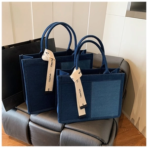 Detail of two patchwork denim tote bags in large and small sizes with top handles