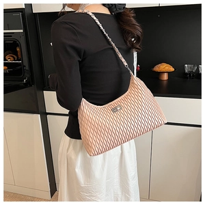 Detail showing high-quality pleated pink faux leather handbag with silver chain strap