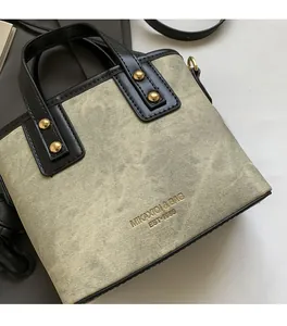 Close-up of bucket bag with washed texture fabric and black leather handle detail
