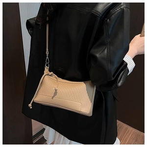 Detailed view of beige pleated underarm bag texture with premium leather edging