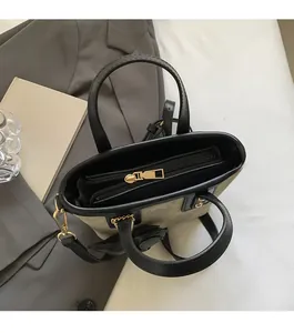 Top view of smooth gold zipper closure and spacious interior of a black leather bucket bag