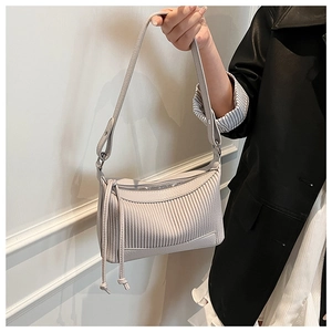 Detail of light grey pleated shoulder bag with long tassel and vertical texture