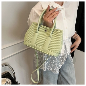 Detail of light green pleated bucket bag showing the unique vertical texture and silver buckle