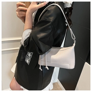 Détail du sac porté épaule baguette crème avec texture matelassée verticale sur cuir