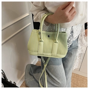 Detail of light green pleated bucket bag with silver buckle and hand-held styling