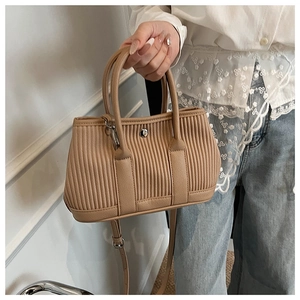 Detail of pleated khaki bucket bag with silver hardware and adjustable shoulder strap