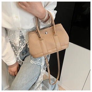 Detail of khaki pleated bucket bag with metal buckle and adjustable shoulder strap