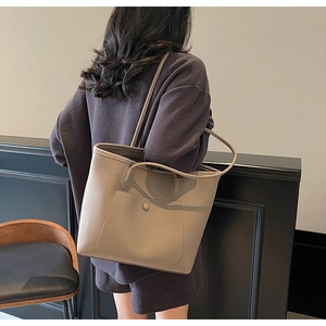 Minimalist khaki lychee texture tote bag with snap pocket shown in an indoor setting
