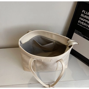Interior view of off-white tote bag showing spacious lining and zipper pocket