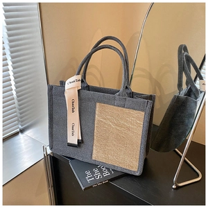 Detail view of the gray felt tote bag featuring a contrast beige pocket and decorative ribbon