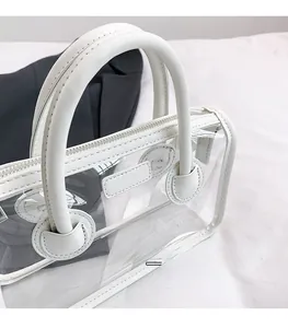 Detailansicht der weißen transparenten PVC-Gelée-Tasche mit Kunstledergriffen und Reißverschluss