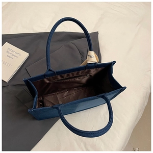 Spacious navy canvas tote bag interior with smooth brown lining and zippered pocket