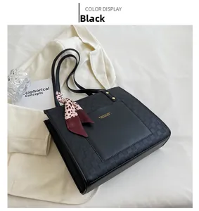 Detail of black tote bag with checkered embossing, gold logo and red leopard scarf