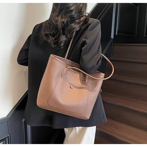 Detailed view of brown litchi grain leather tote bag with a functional exterior pocket