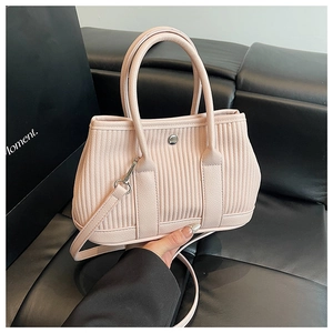 Close-up of pleated pink bucket bag with vertical ripples and silver metal button detail
