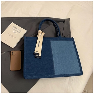 Detail of patchwork denim tote bag with decorative silk scarf and spacious compartment
