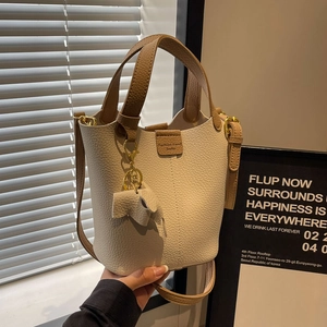Litchi pattern bucket bag in cream and brown with elephant charm and shoulder strap