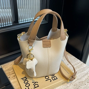 Creamy white lychee texture bucket bag with brown handles and a cute elephant charm