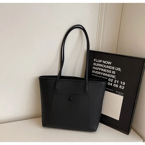 Detail of black tote bag featuring premium lychee pattern leather and slim shoulder straps