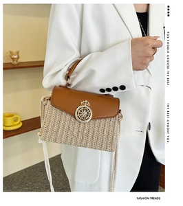 Detail of straw woven box bag with leather trim and gold crown nautical clasp