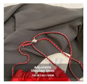 Close-up of red ruched bag showing litchi texture and adjustable silver ball chain strap