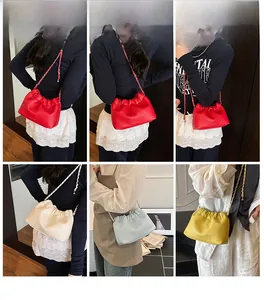 Detail showing various colors of ruched cloud crossbody bags with chain straps