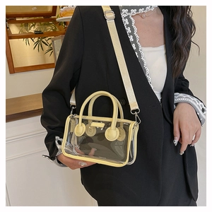Detail der transparenten PVC-Gelee-Tasche mit gelbem Besatz und dickem Webbandriemen