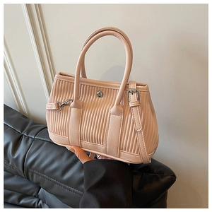 Detail view of pink pleated PU leather tote bag with silver round buckle and shoulder strap