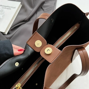 Brown and black tote bag interior showing the zipper pocket and magnetic snap closure