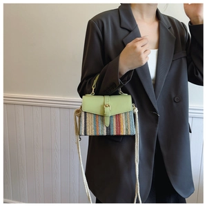 Détail d'un sac bandoulière tissé avec rabat en cuir vert et texture textile colorée