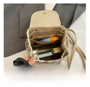 Interior view of beige drawstring backpack showing space for cosmetics and lotions