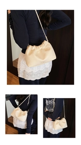 Detail of creamy white pleated cloud bag showing lychee grain leather and metal chain strap