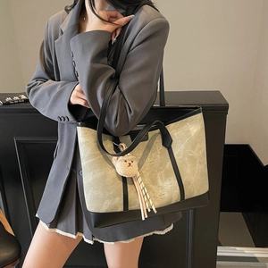 Large marbled tote bag with black trim and bear charm shown on a stylish model