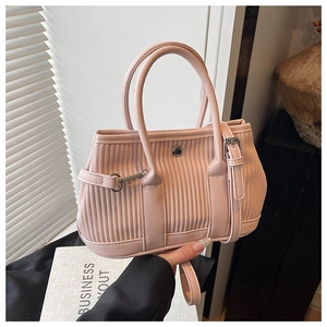 Detailed view of pink ribbed leather tote with elegant metal buckles and dual handles