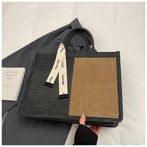 Detailed view of color-block canvas tote bag with silk ribbon detail and texture