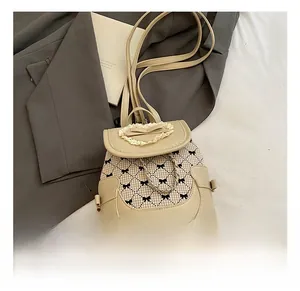 Detailed close-up of beige bow backpack with lace trim and fine checkered fabric pattern