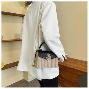 Detail of straw and leather patchwork bag with golden crown clasp and rope strap