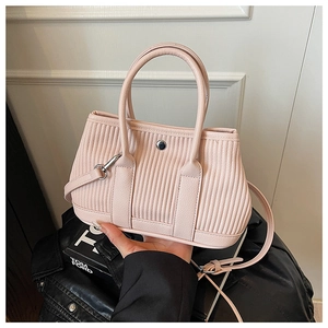 Detail of light pink pleated bucket bag with silver round clasp and adjustable strap