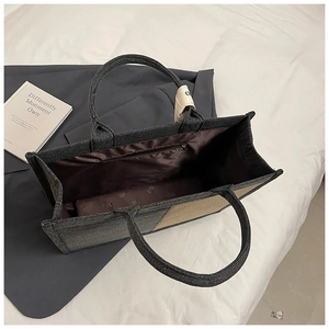 Detail of spacious denim canvas tote bag with inner zipper pocket and logo lining