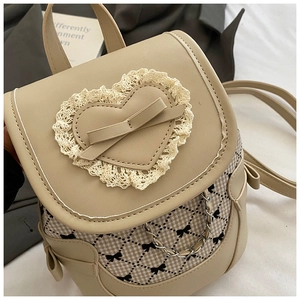 Dettaglio mini zaino beige con finiture in pizzo, fiocchi e tessuto pied de poule chic