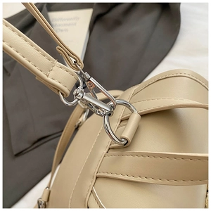 Dettaglio della chiusura in metallo argento e tracolla in pelle PU beige dello zaino