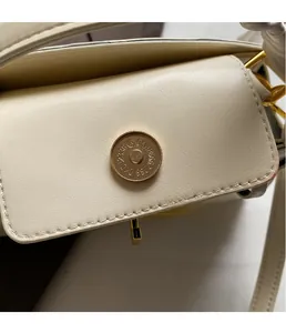 Vue macro détaillée de la boucle magnétique dorée et du cuir texturé du sac à main