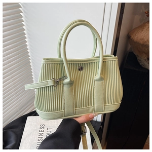 Detail of mint green pleated bucket bag with silver metal ring and round handles