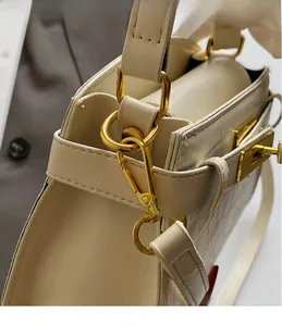 Détail de sac à main Kelly crème avec motif crocodile et fermoirs dorés brillants