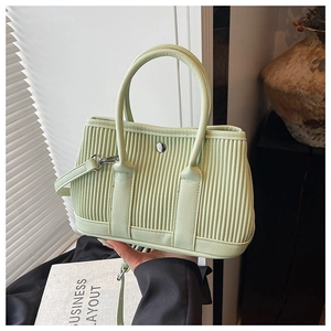 Detail of mint green pleated bucket bag with metallic magnetic buckle and round handles