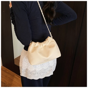 Close-up of cream lychee pattern leather texture and elegant gold metal chain strap on bag