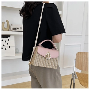 Detail of woven straw crossbody bag with pink leather flap and metallic lock